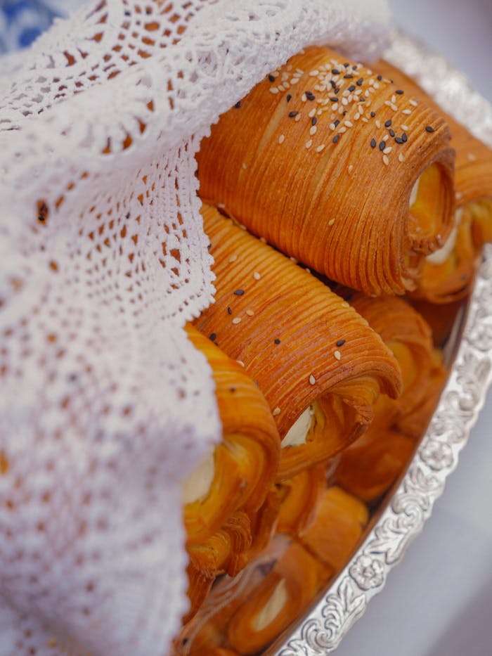 services-02 Close-up of homemade Hungarian pastries on a decorative plate under lace cloth.